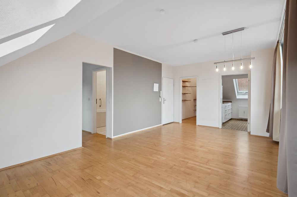 Helles, leeres Zimmer mit Parkettboden, großen Fenstern und Zugang zu Bad, Abstellraum und weiterem Raum.