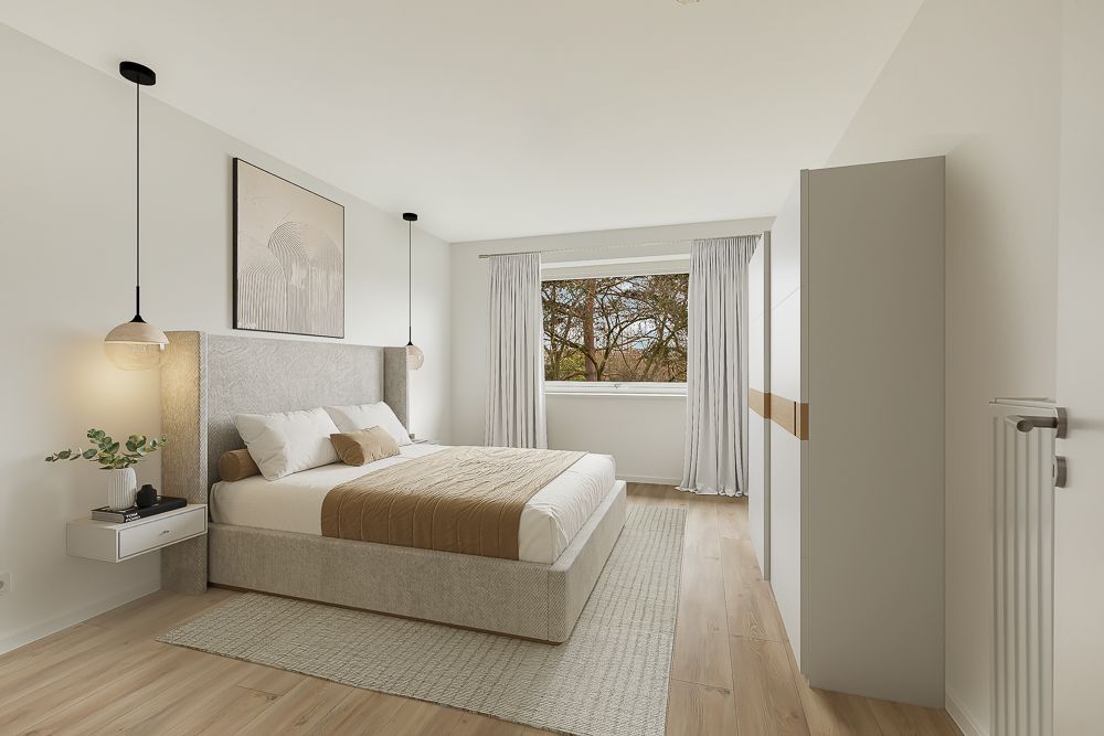 Helles Schlafzimmer mit Doppelbett, großem Fenster, Kleiderschrank und Holzfußboden.