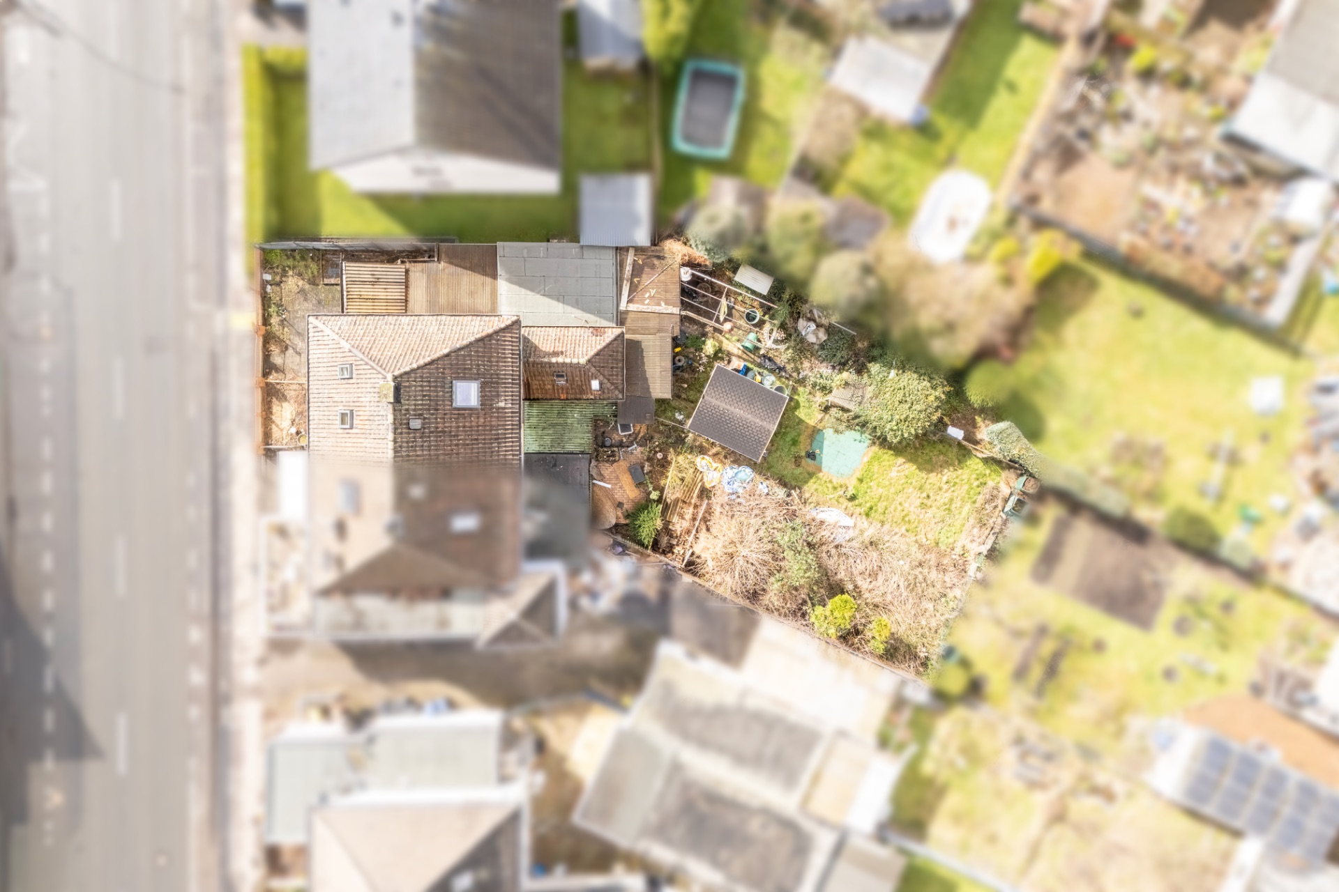 Luftaufnahme eines Wohnhauses mit Garten und angrenzenden Gebäuden.