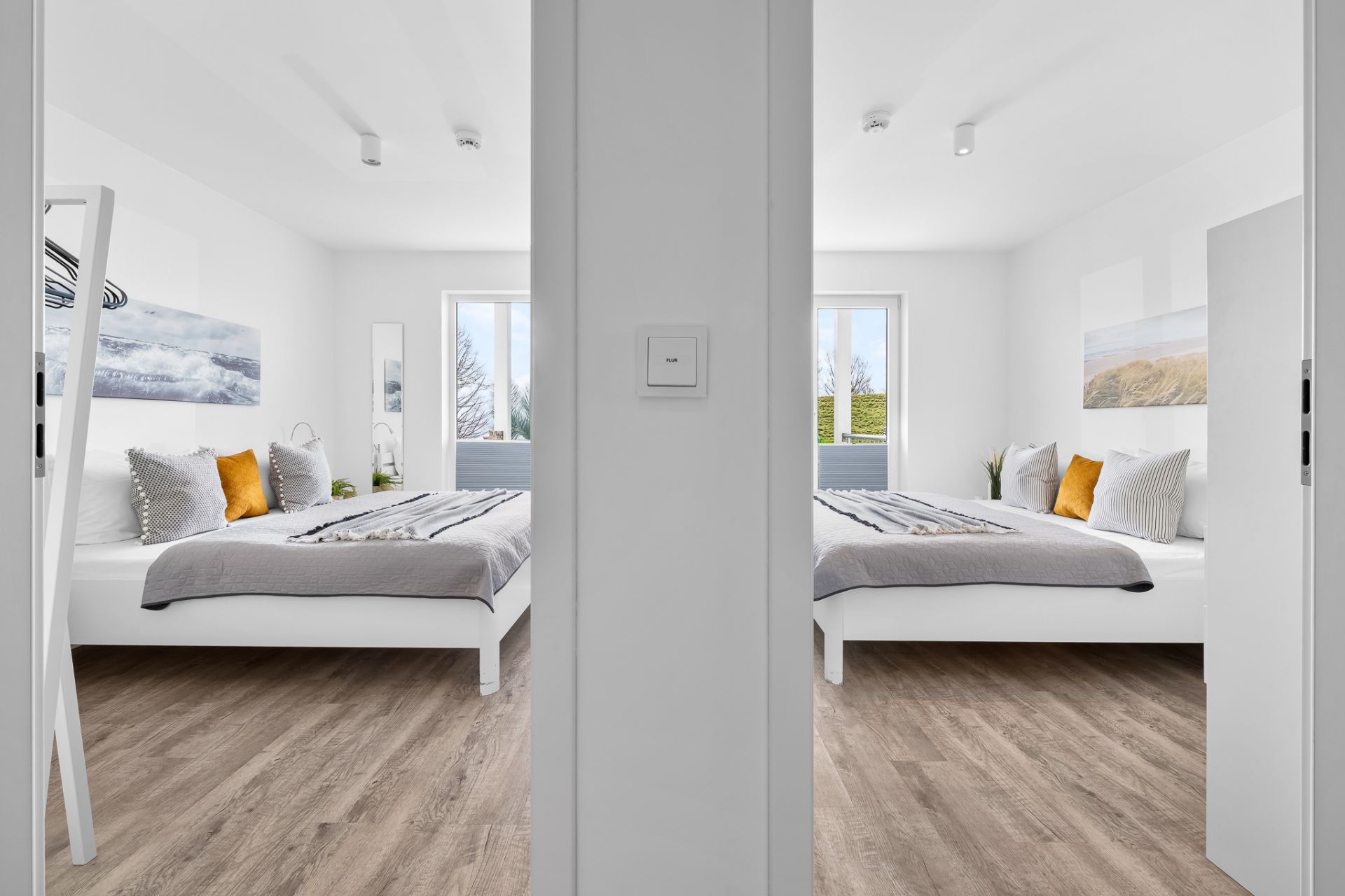 Zwei identisch eingerichtete Schlafzimmer mit Doppelbett, Holzboden und großen Fenstern.