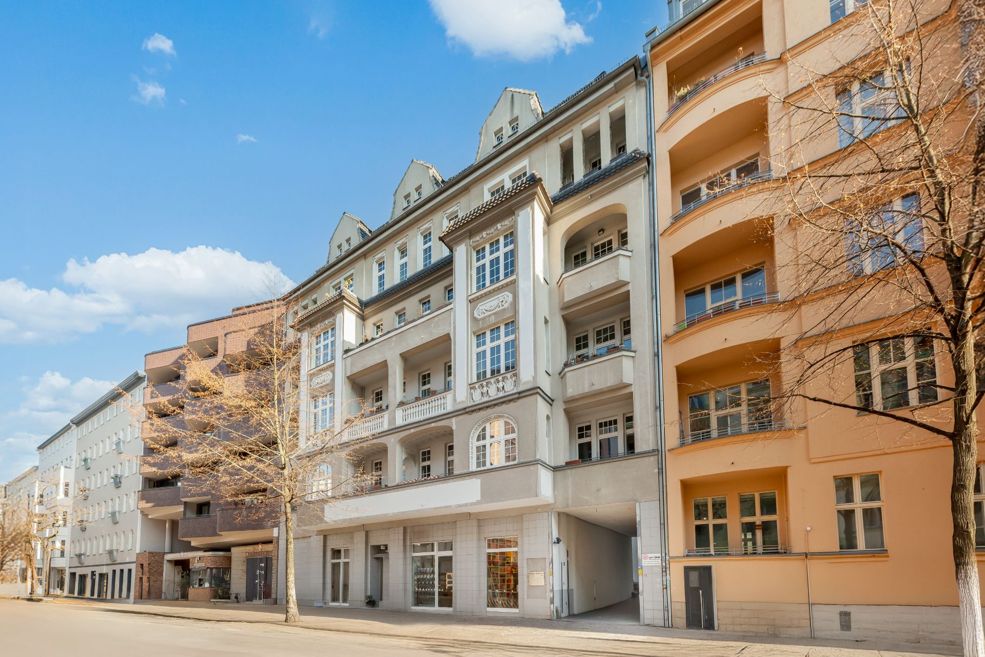 Mehrstöckiges Wohnhaus mit Balkonen und großen Fenstern an einer ruhigen Straße.