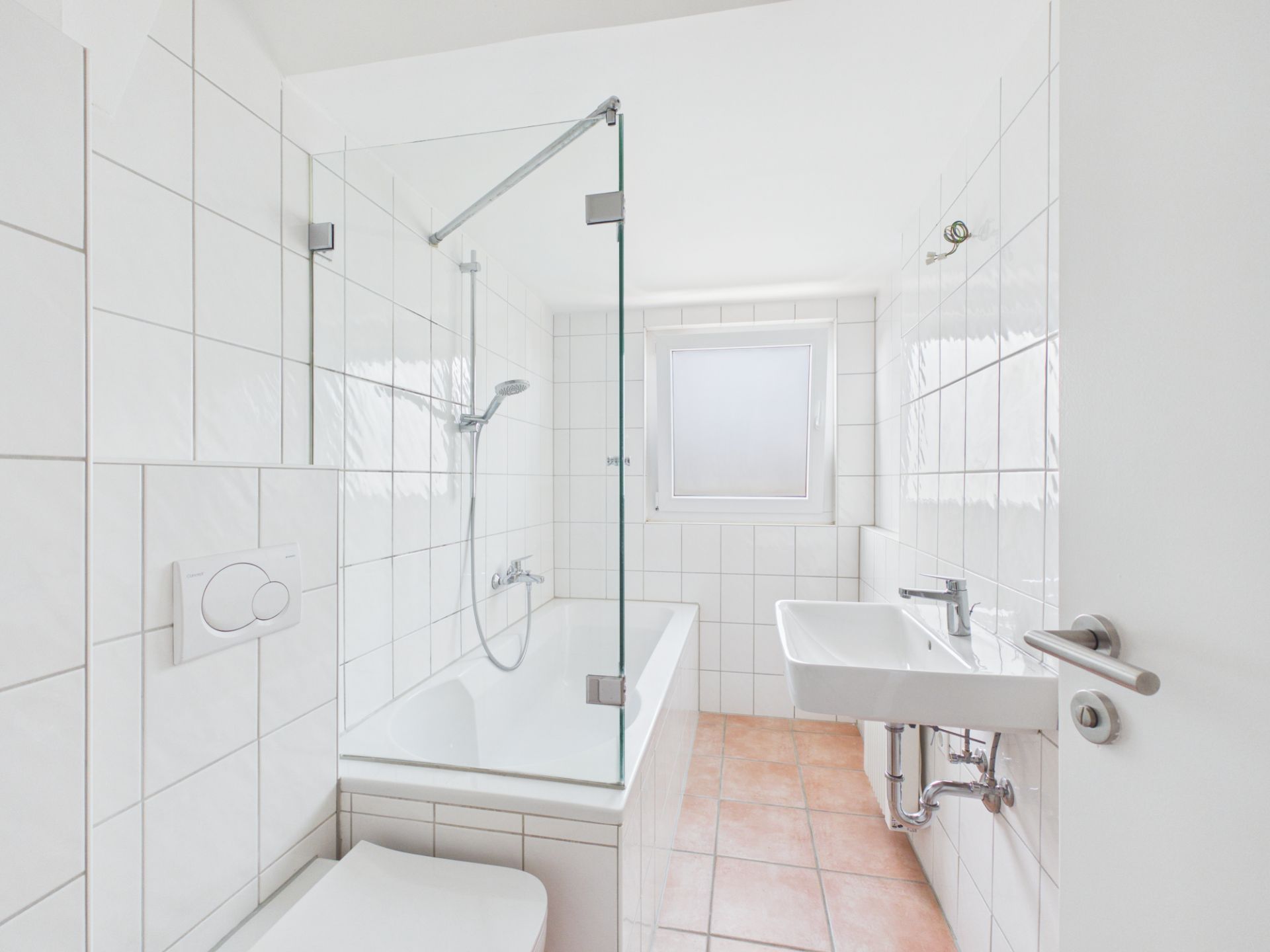 Helles Badezimmer mit Badewanne, Glaswand, Waschbecken und Fenster.