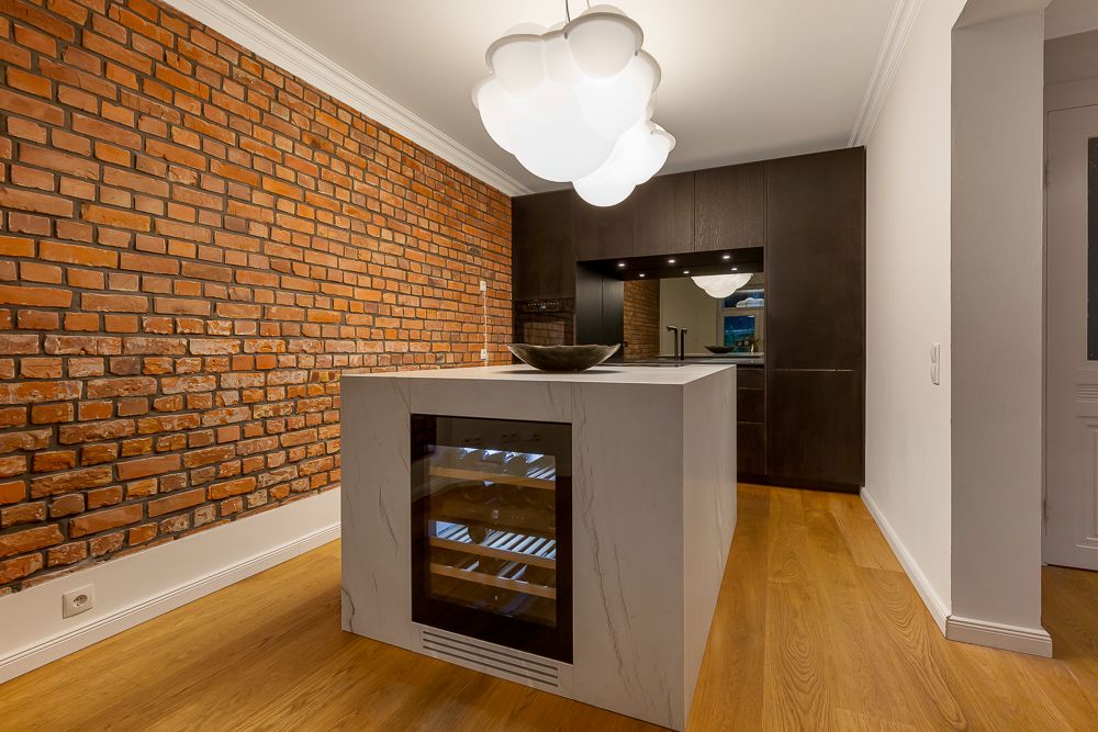 Moderne Küche mit Ziegelwand, Kücheninsel mit Weinkühlschrank und großem Deckenlicht.