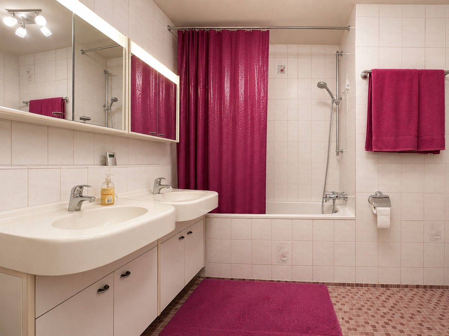 Badezimmer mit zwei Waschbecken, Badewanne, pinkem Duschvorhang und passenden Handtüchern.