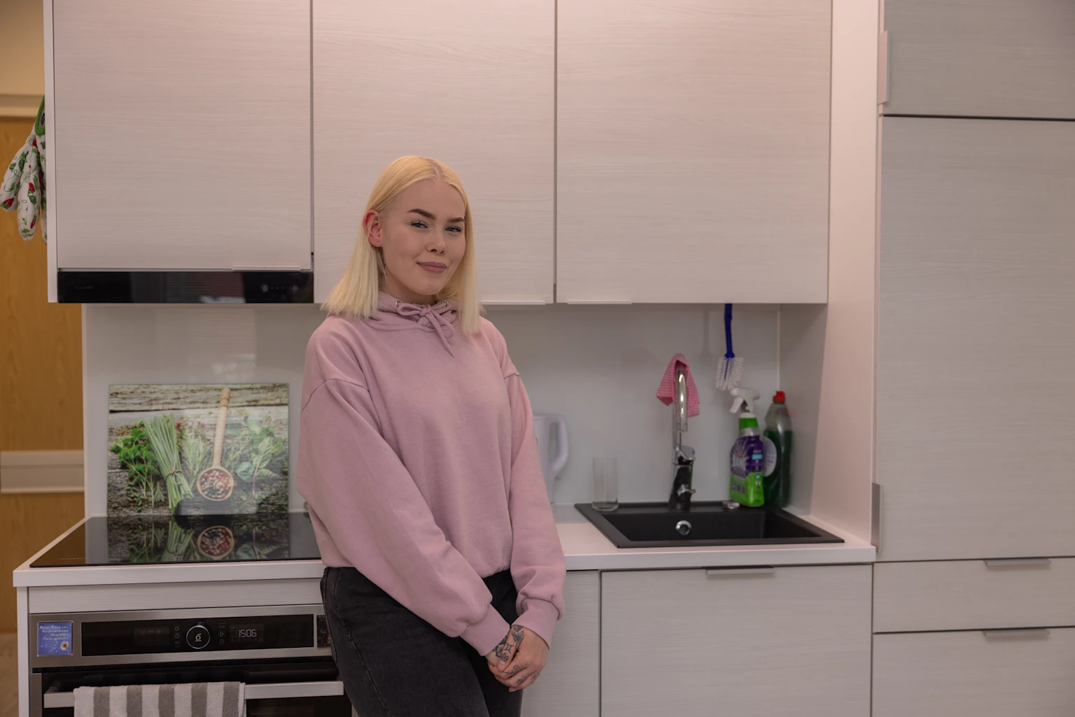 Asukastarina, kuva keittiöstä, jonka edessä seisoo Joo Kotien asukas