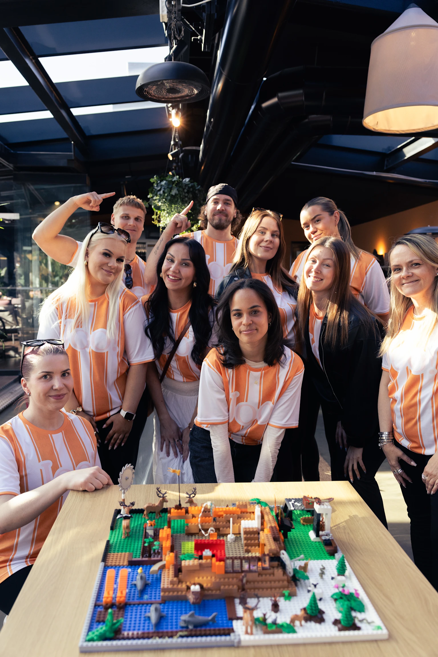 Oranssijoukkue hymyilee kuvassa Joo-päivänä kilpailun voittamisen jälkeen.