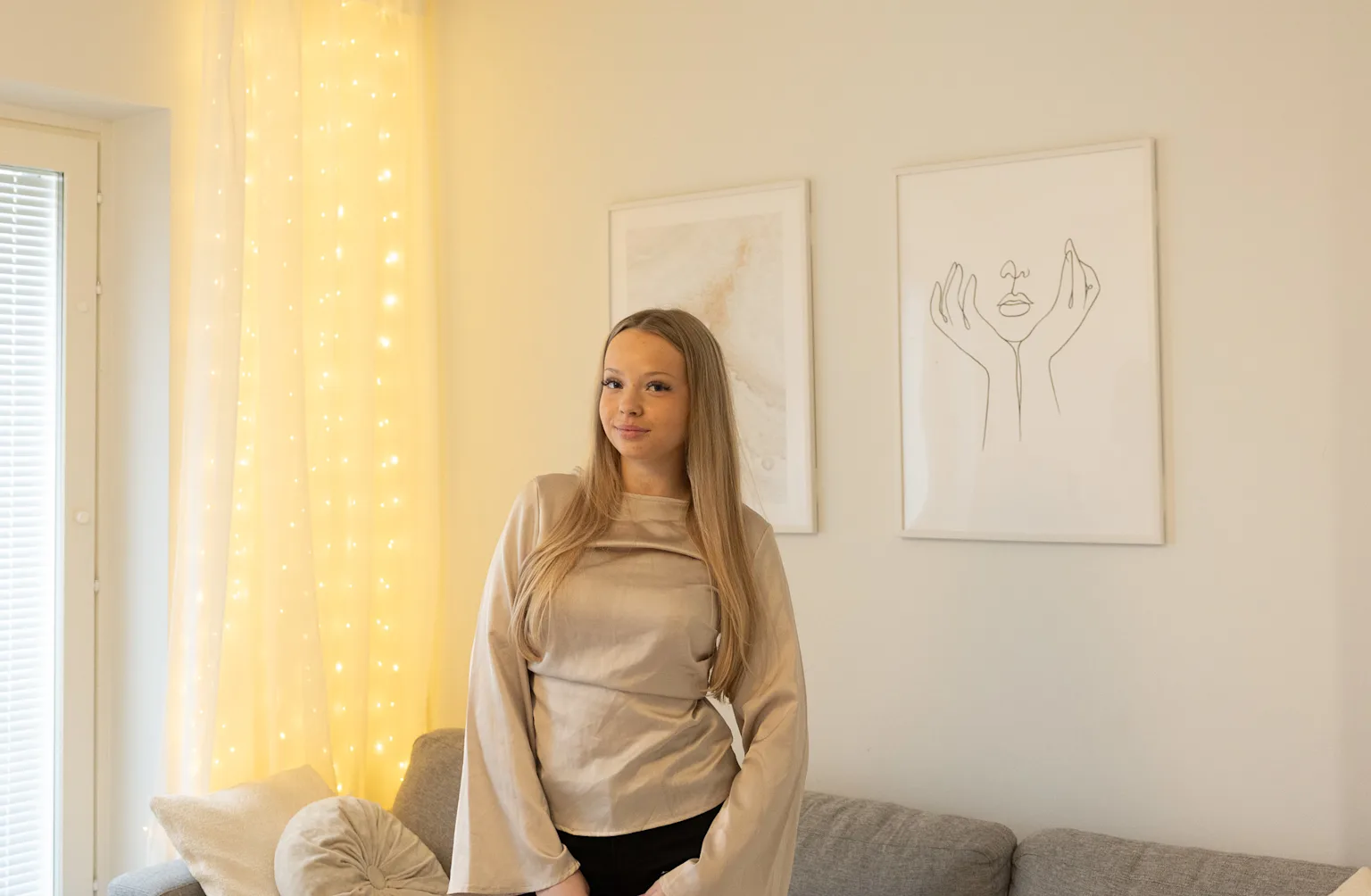 Asukas, joka seisoo vuokra-asuntonsa olohuoneessa. 