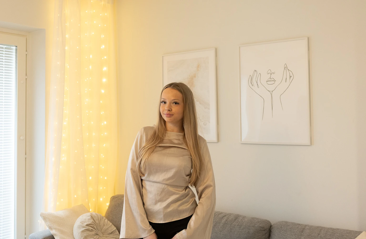 Asukas, joka seisoo vuokra-asuntonsa olohuoneessa.