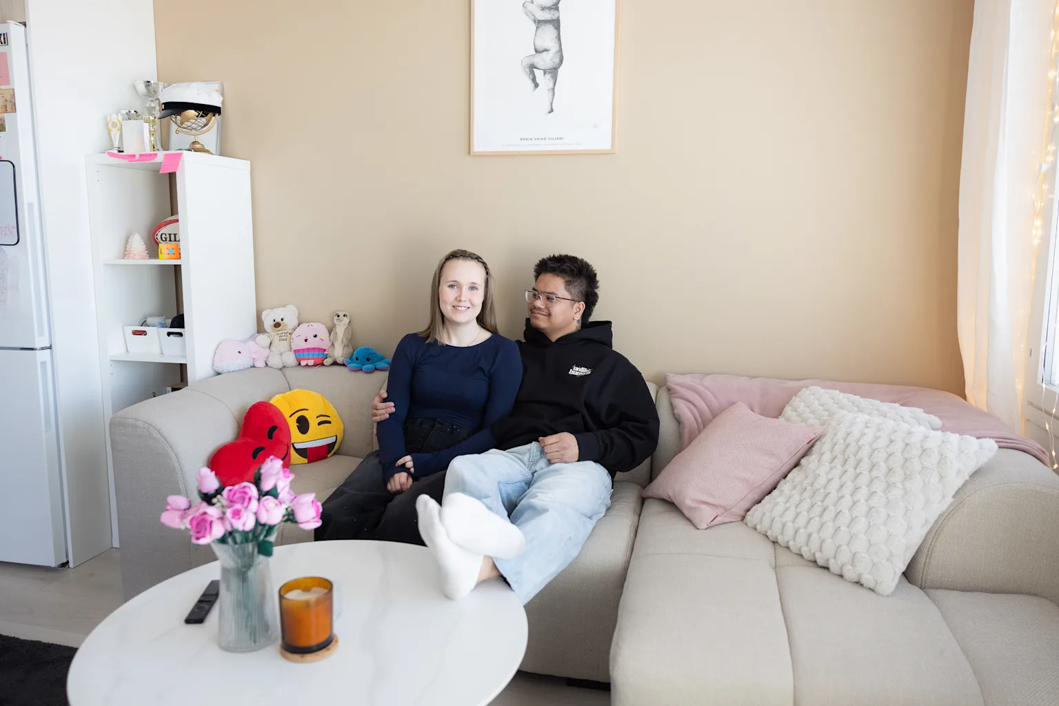 Oona-Olivia and Melvin are sitting on the sofa in their shared Joo Kodit home.