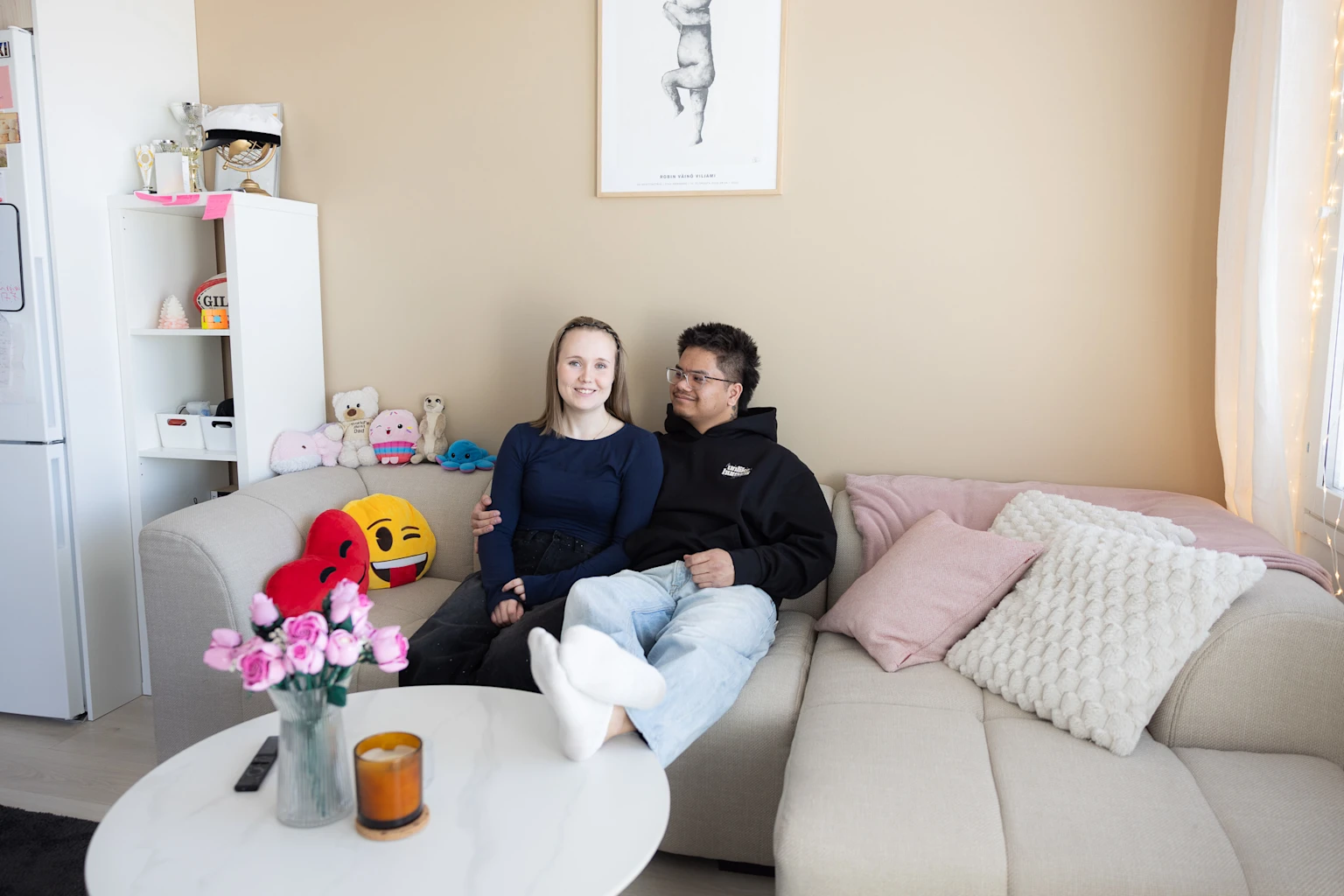 Oona-Olivia and Melvin are sitting on the sofa in their shared Joo Kodit home.