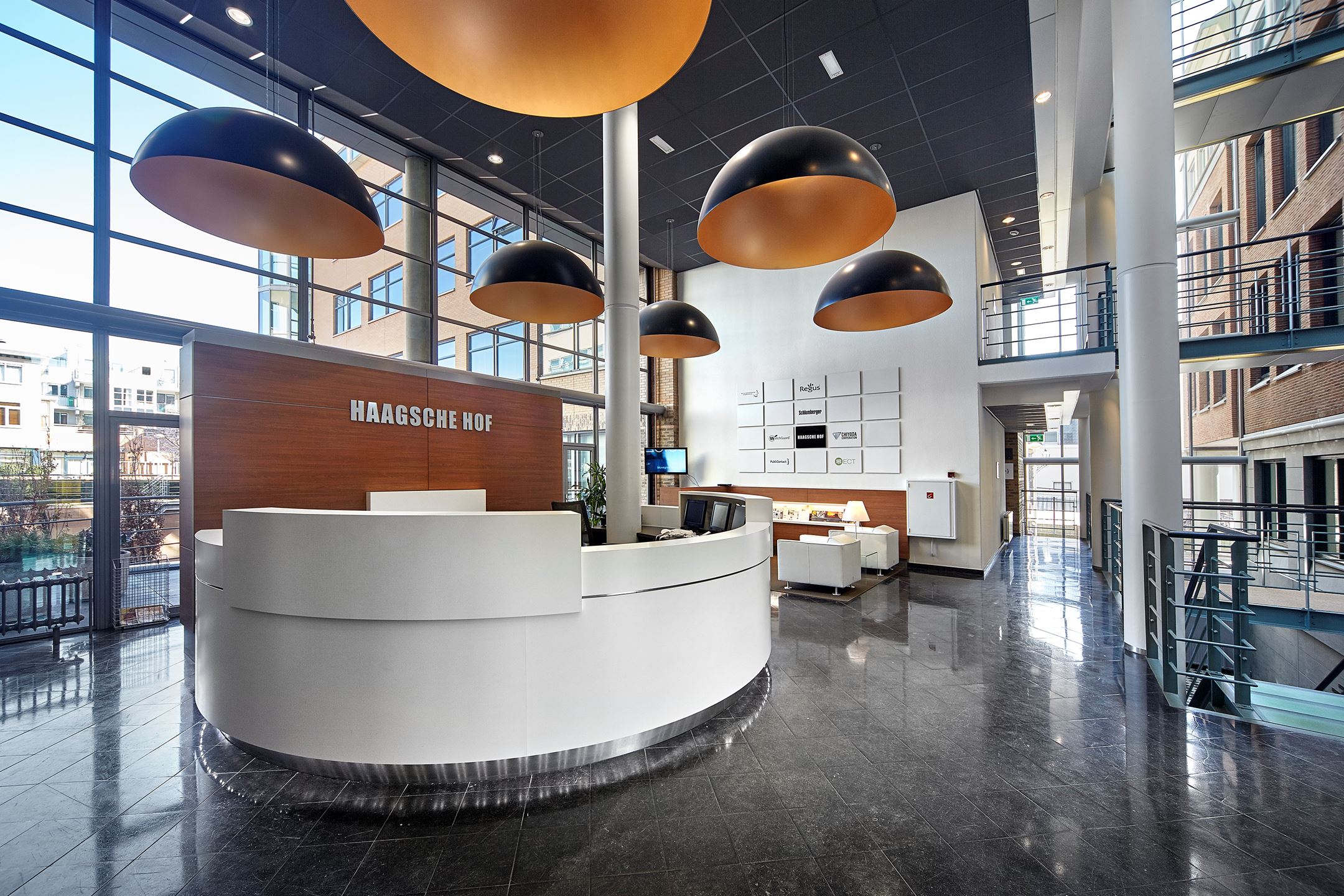 a lobby with a reception desk and large windows
