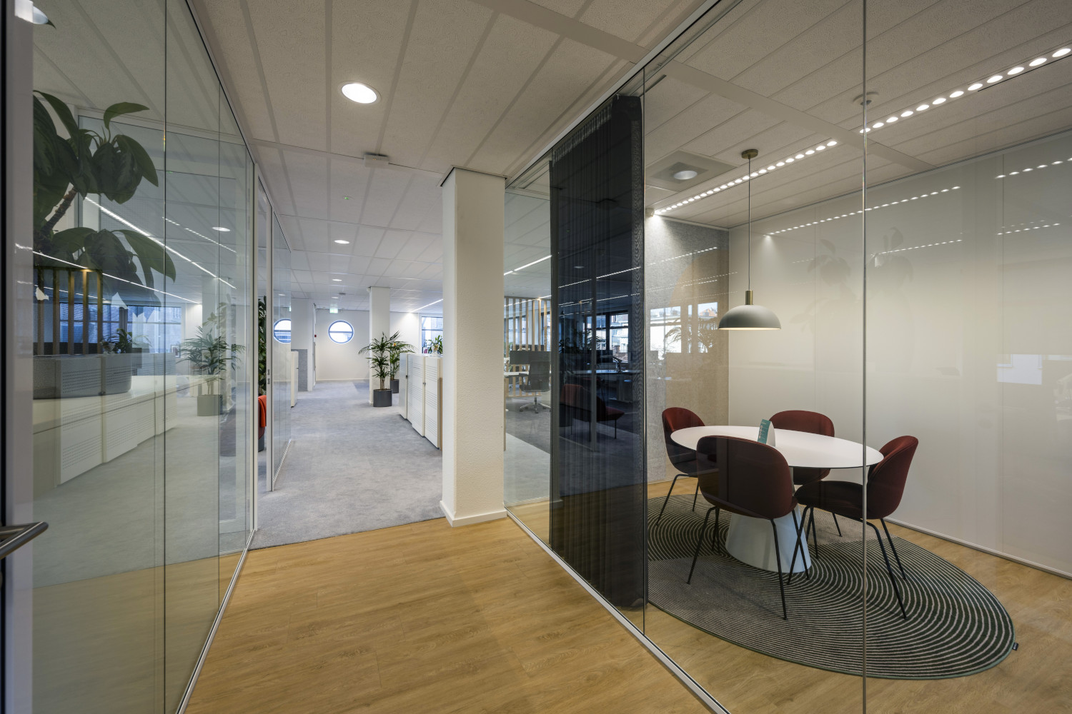 a glass walled meeting room with a table and chairs