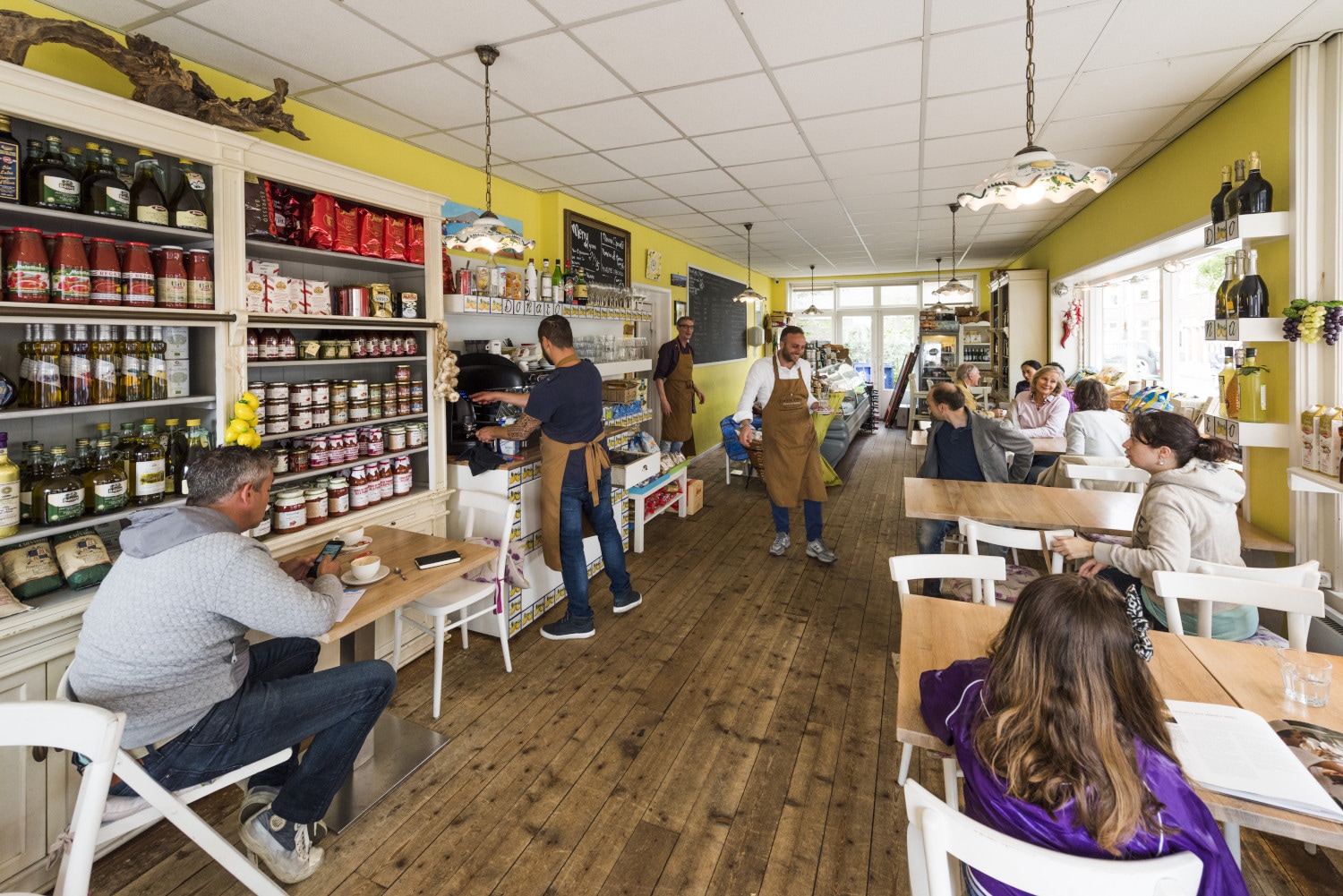 a group of people sitting at tables in a restaurant