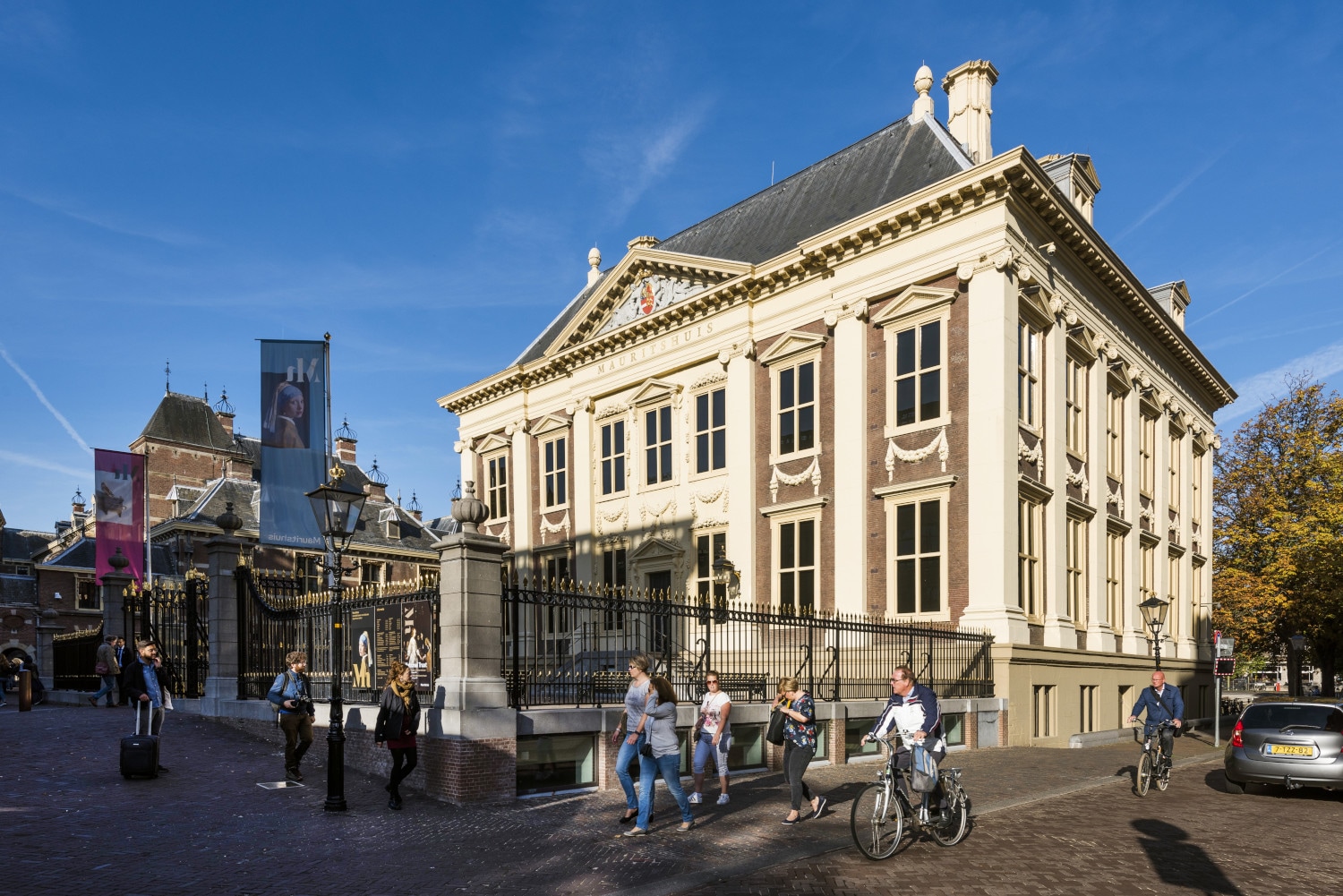 a group of people walking down a street next to a tall building