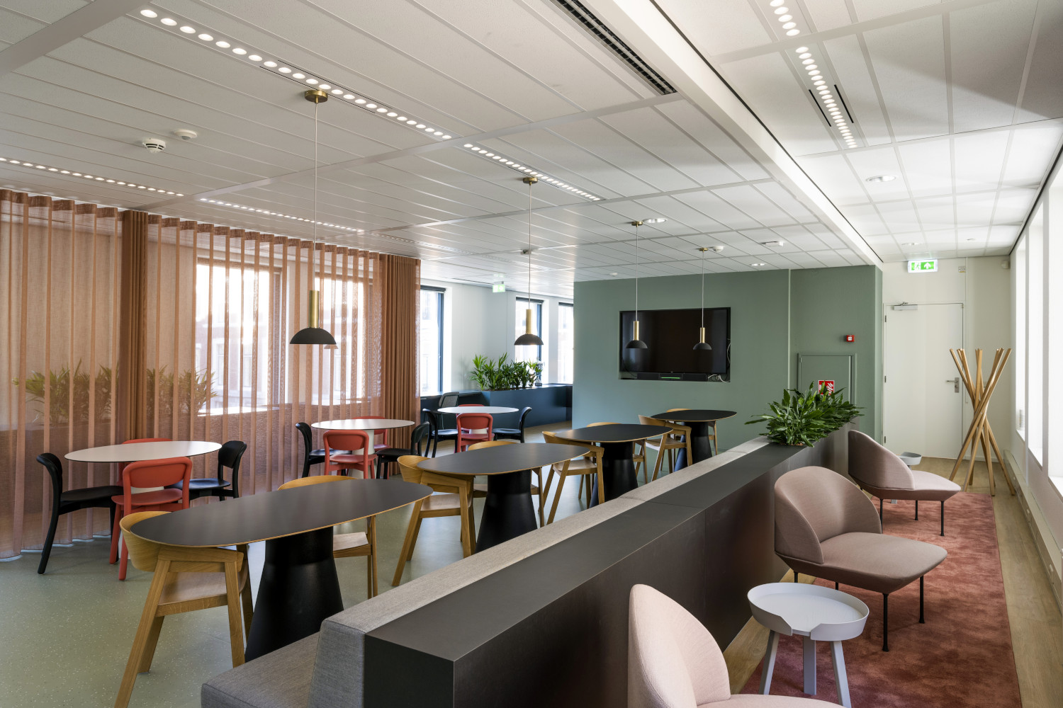 a room with tables, chairs, and a television