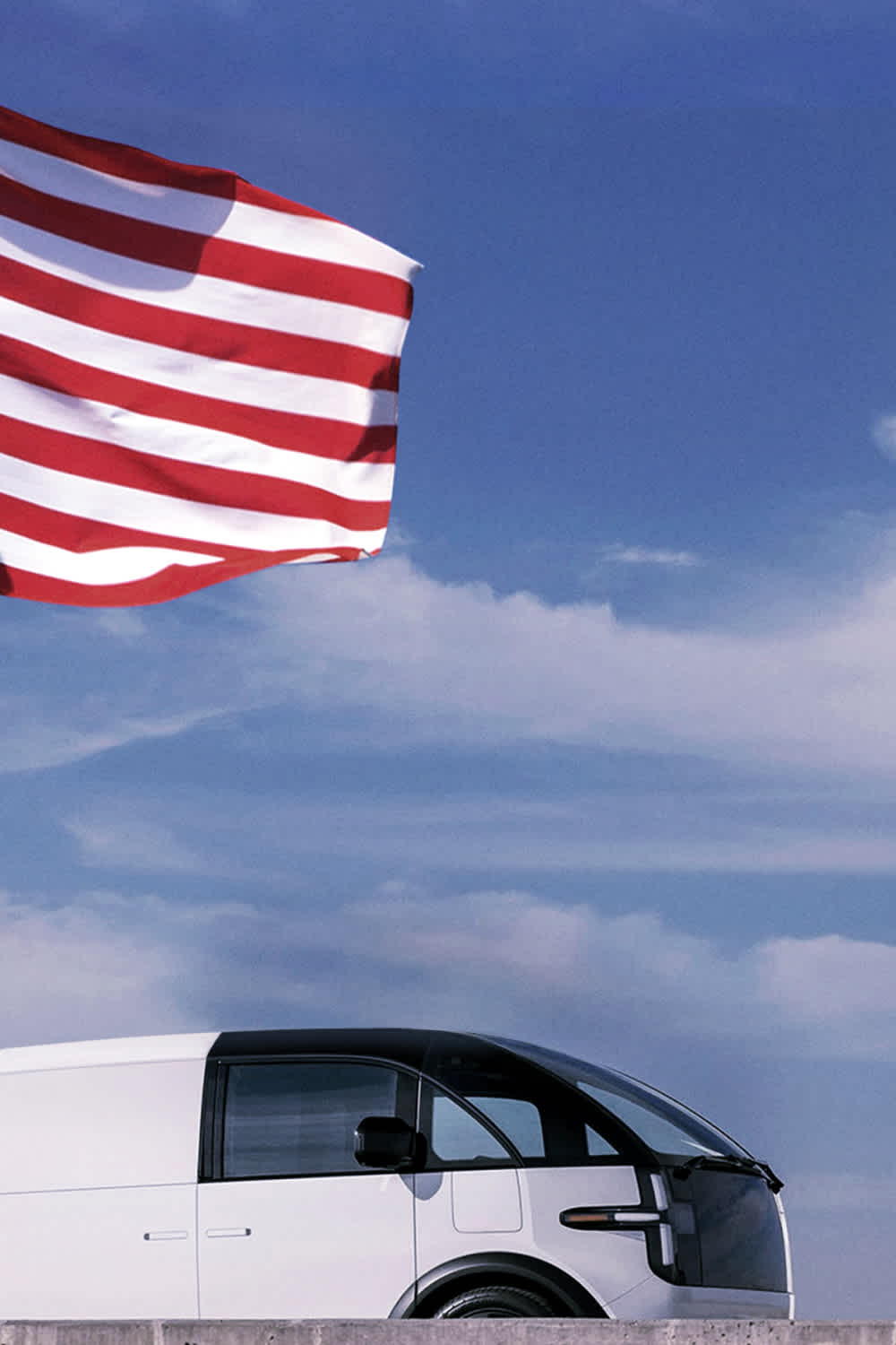 US flag waving next to Canoo fleet vehicle