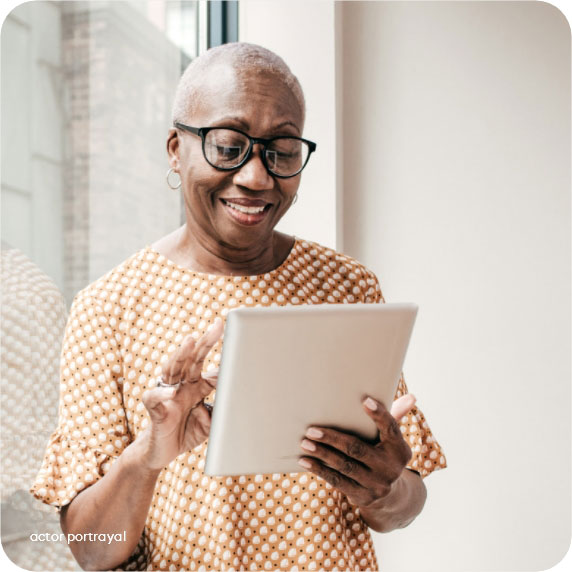 Actor portrayal of a smiling woman using a tablet