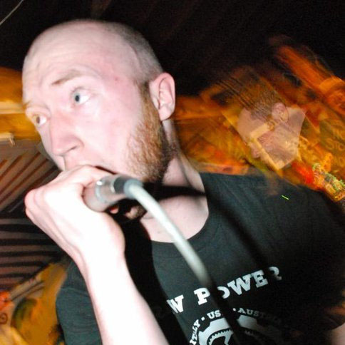 Quincy screaming into a mic, looking up