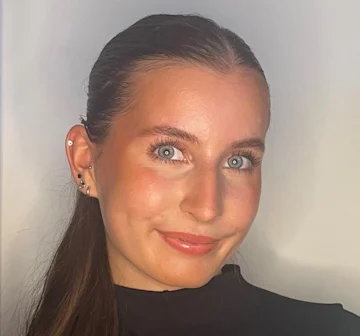 A photo of Grace, a young woman with long brown hair and blue eyes.