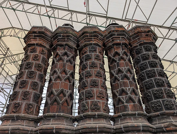 The restored chimneys on the Bramall Hall roof. They have a brick lattice effect, and are surrounded by scaffolding. 