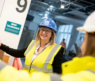 Jo, Construction Lead, wearing a hard hat and high visibility jacket.