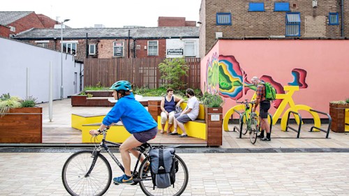 People using the public space near Redrock to cycle and chat.