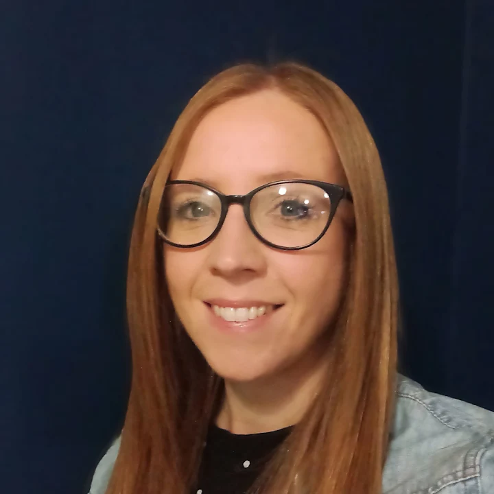 Jenni Bramwell, a young woman with glasses and long auburn hair, smiling at the camera.