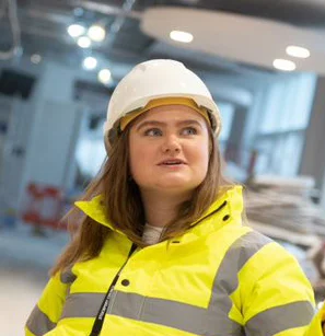 Claudia, Student Building Surveyor wearing a hard hat and high visibility jacket.