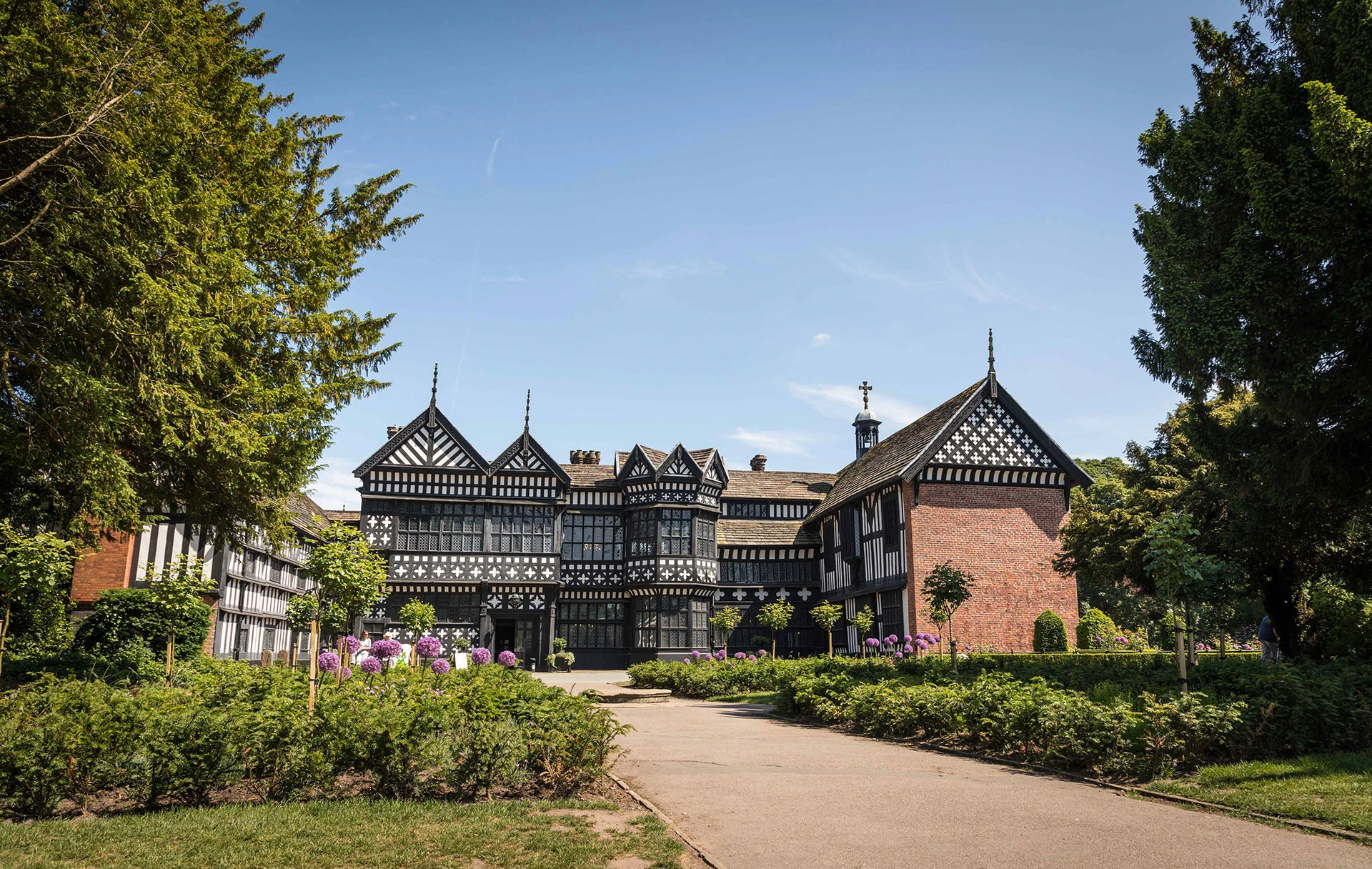 Bramall Hall, a large Tudor building, and the green park surrounding it.