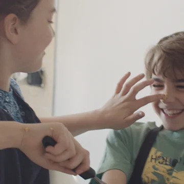 girl putting cake mix on boy's nose