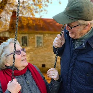 older couple, woman on a swing