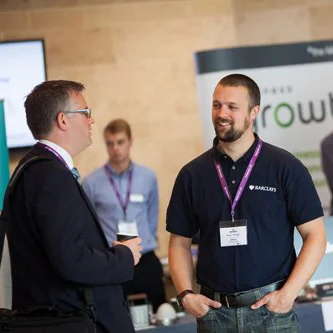 Two men standing up talking