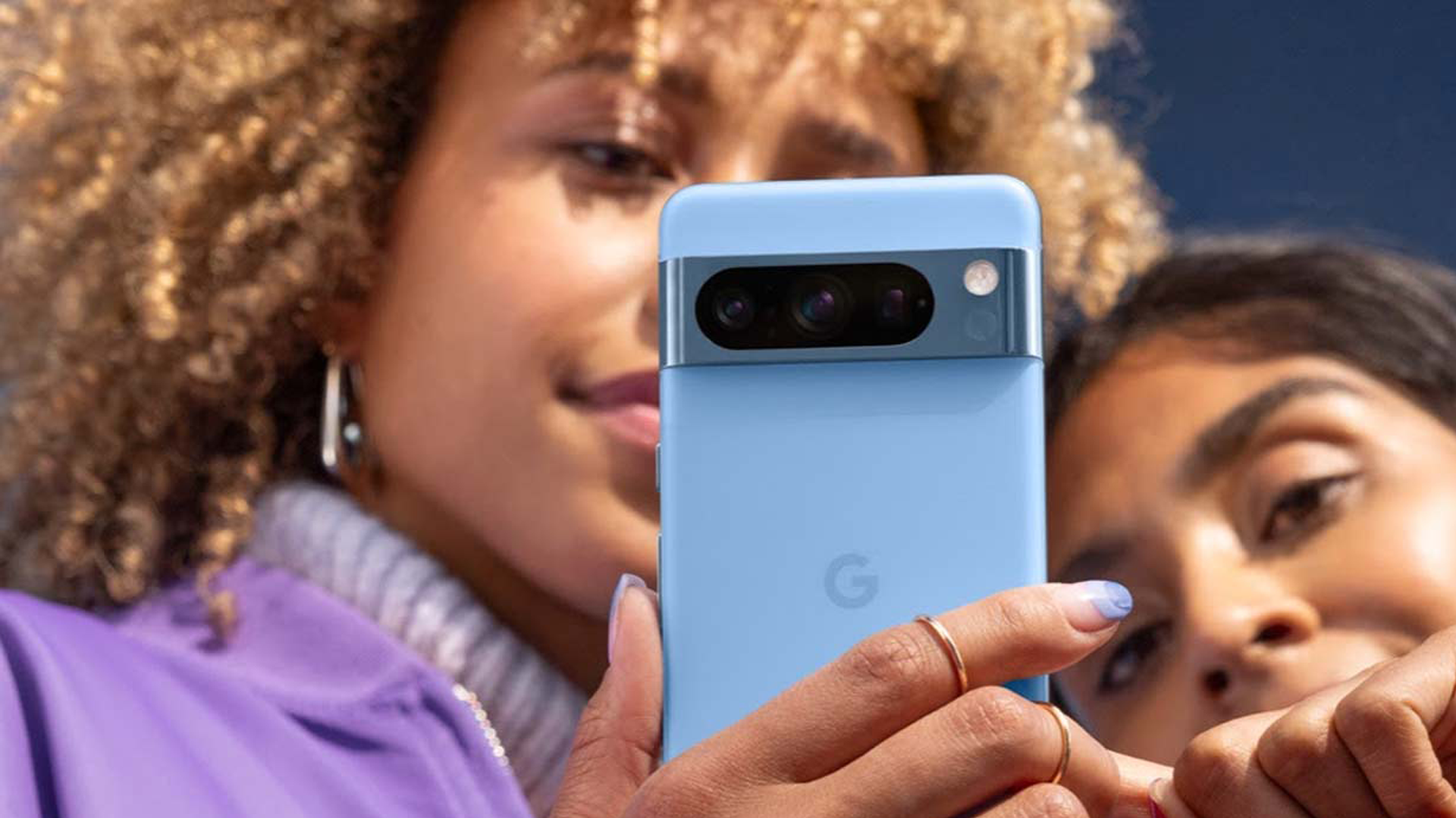 Två kvinnor tittar på en Google Pixel 8 Pro