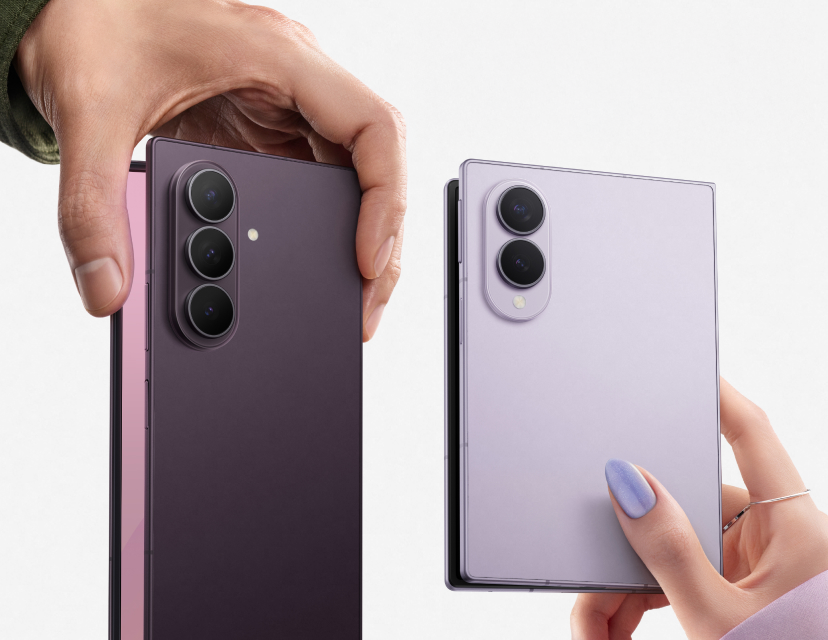 Två händer håller Samsung Galaxy Z Fold8-telefoner i lila och ljuslila färg, visande baksidan med kameror.