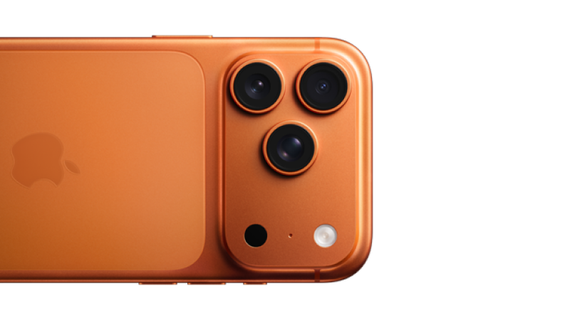 Närbild på en orange iPhone 17 Pro med tre kameralinser i ett triangelformat arrangemang på baksidan.