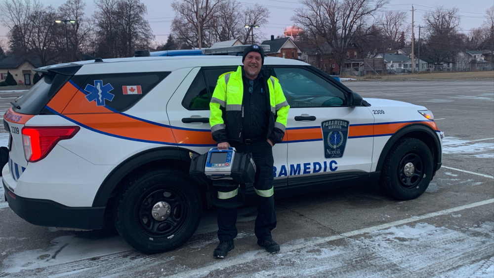 Norfolk county paramedic standing in front of his paramedic vehicle