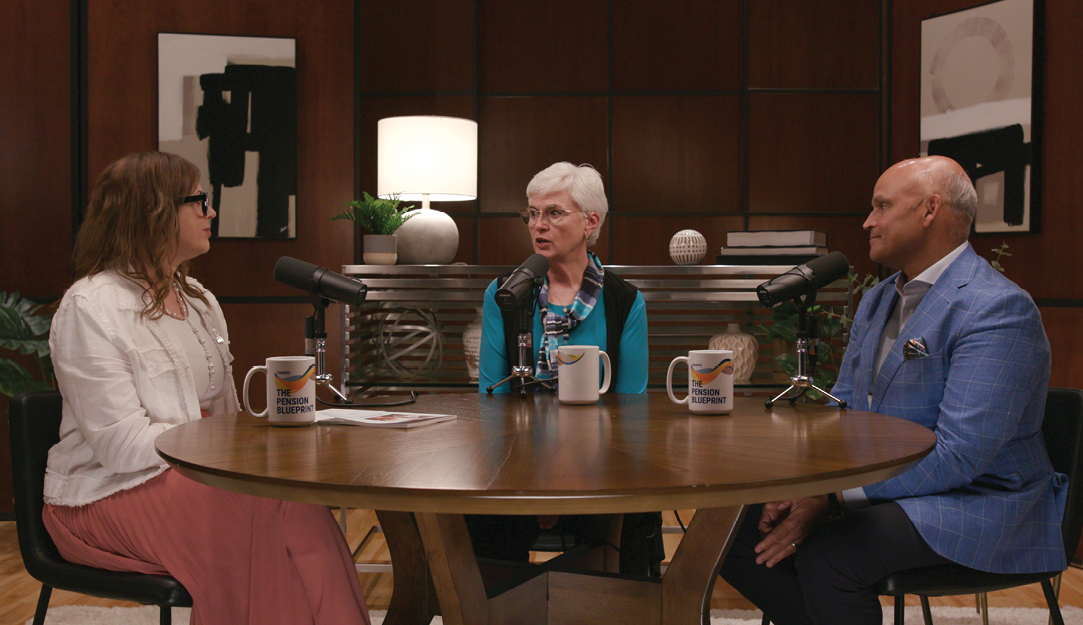 Three people sitting at a table with microphones