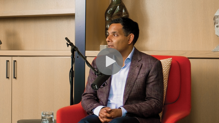 Dr Samir Sinha sitting at a microphone