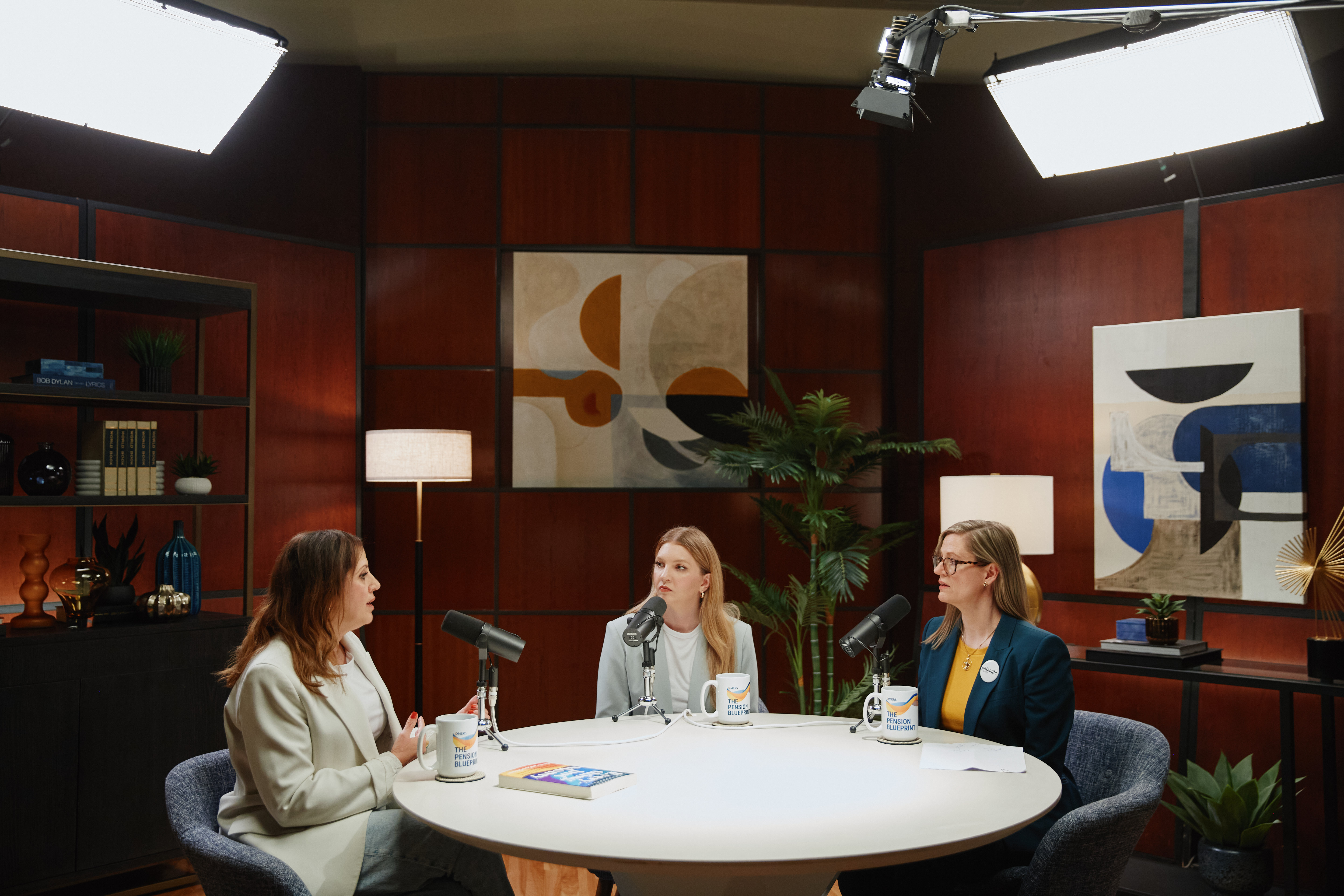Three women sitting at a table with microphones