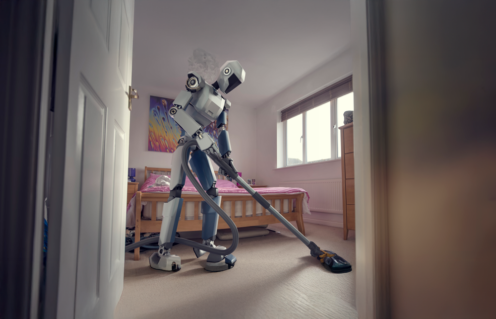 A humanoid robot vacuuming a bedroom