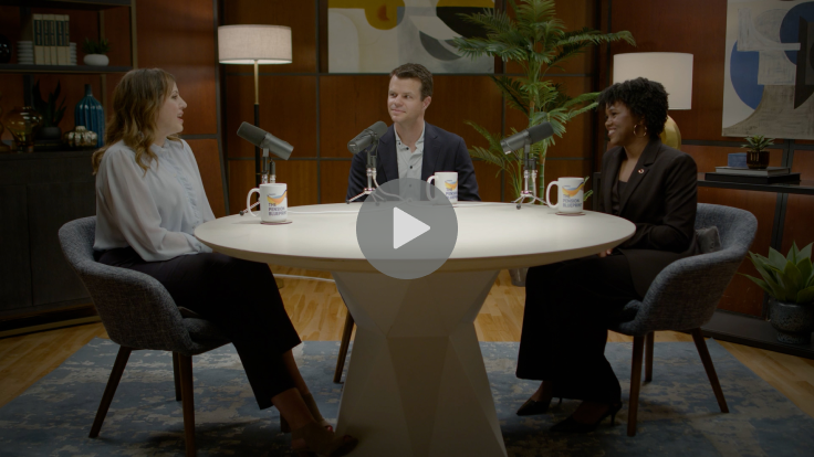 Three people sitting at a table with microphones