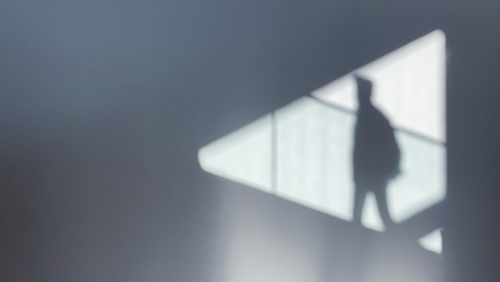 A shadow on a wall of a person walking up stairs