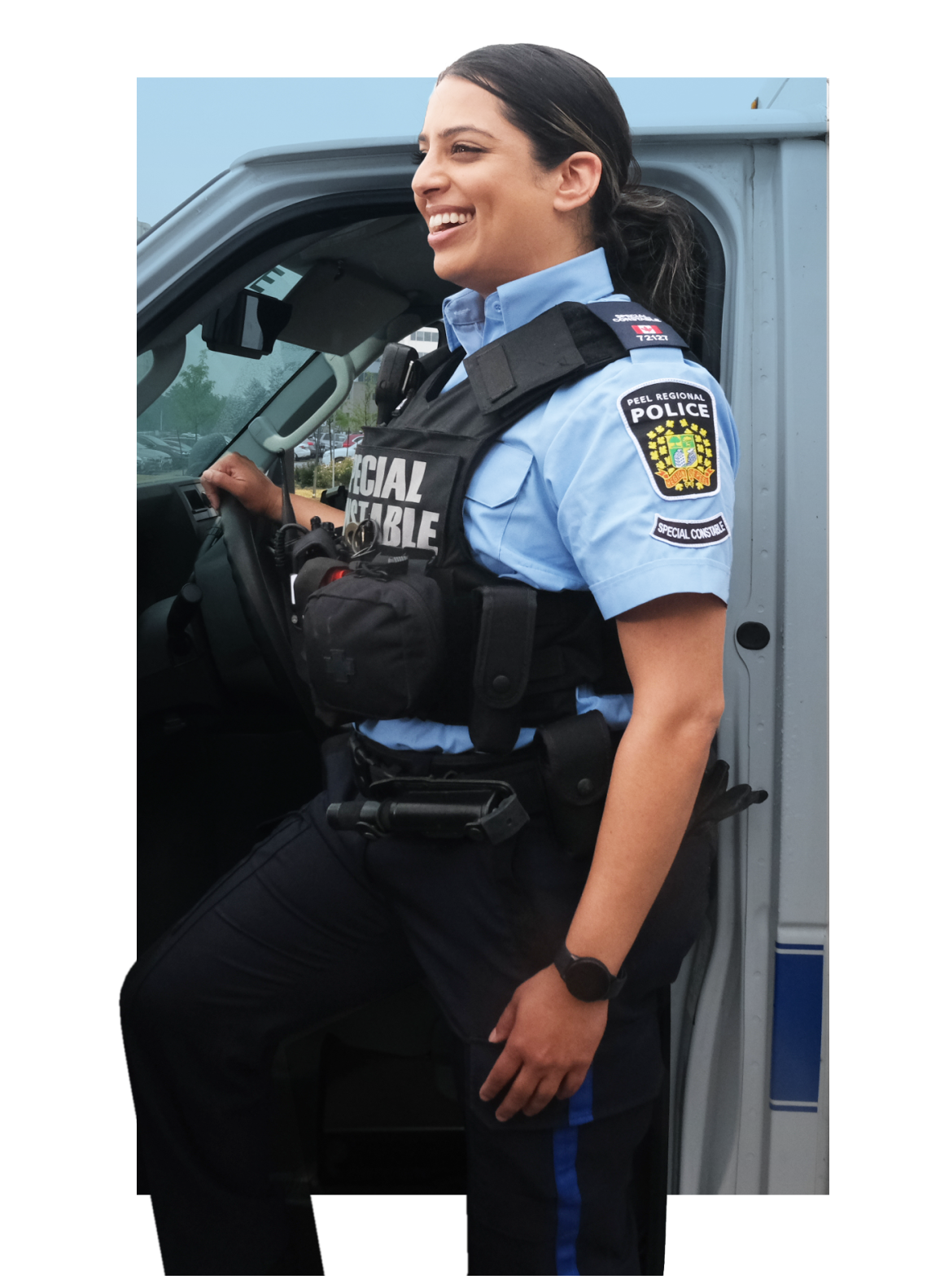 Female Peel Regional Police Officer member smiling while exiting her vehicle 