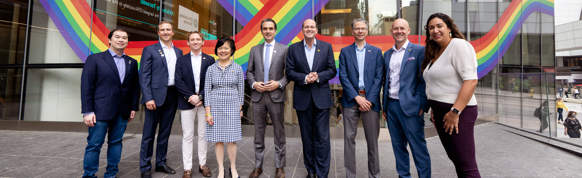  OMERS President and CEO, Blake Hutcheson, with several OMERS employees outside of the EY Tower Toronto office building celebrating Pride Month