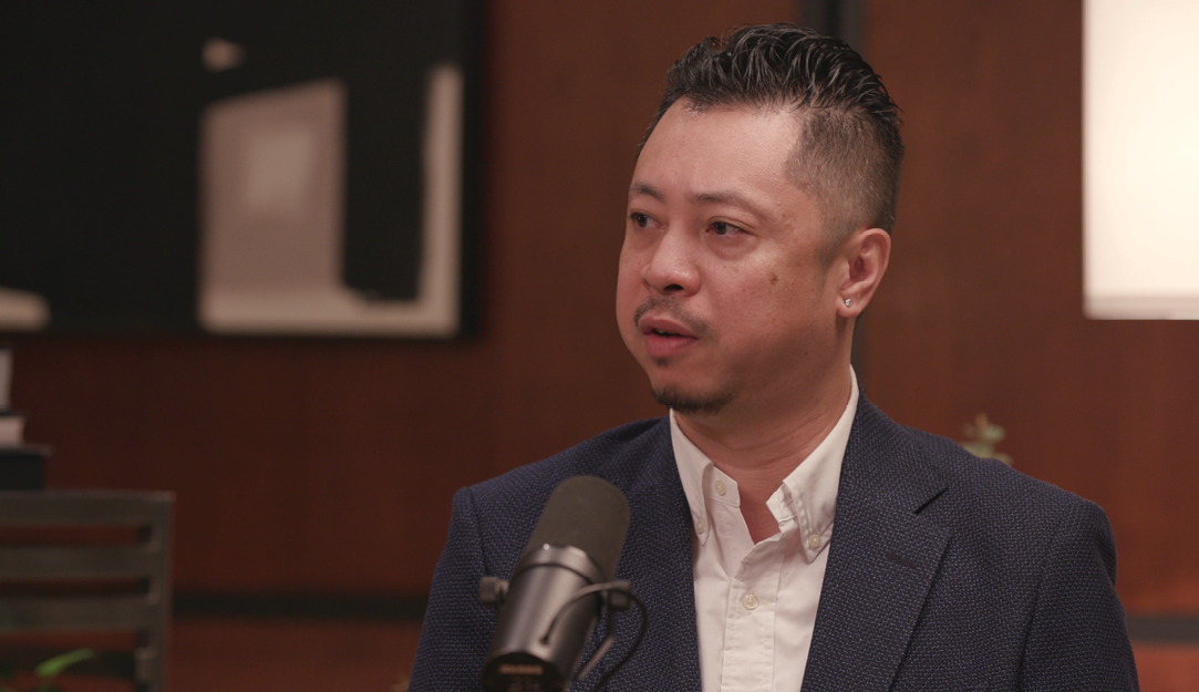 A man sitting at a table with a microphone