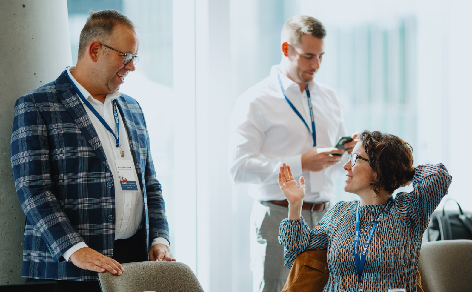 two men and a woman speaking at a work event