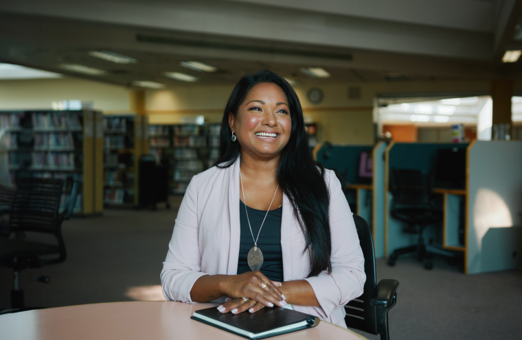 a woman sitting at a table in a library