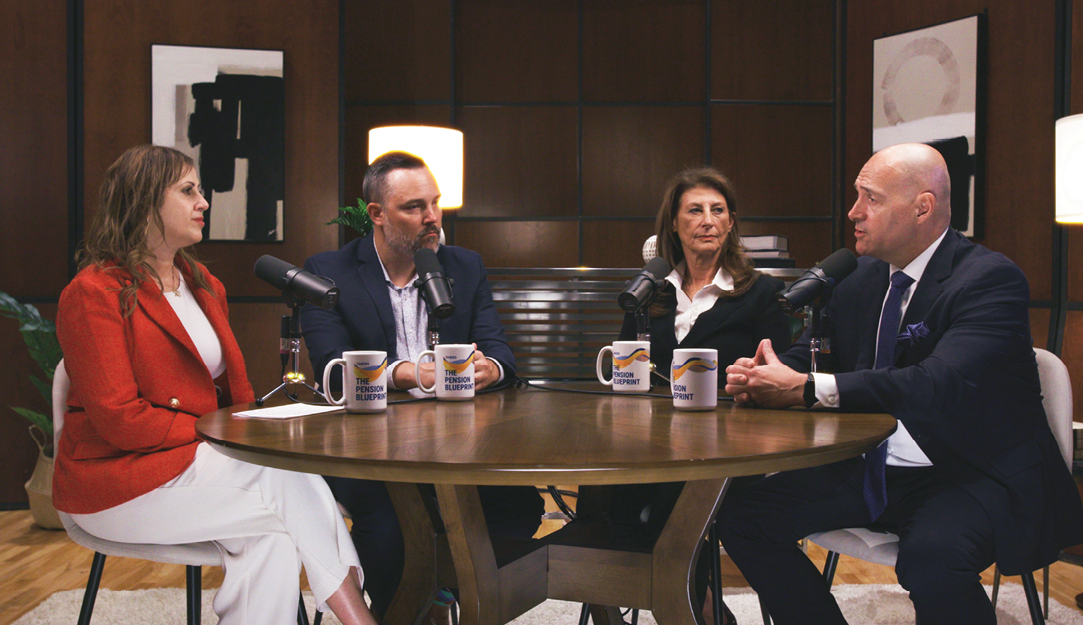 Four people sitting at a table with microphones