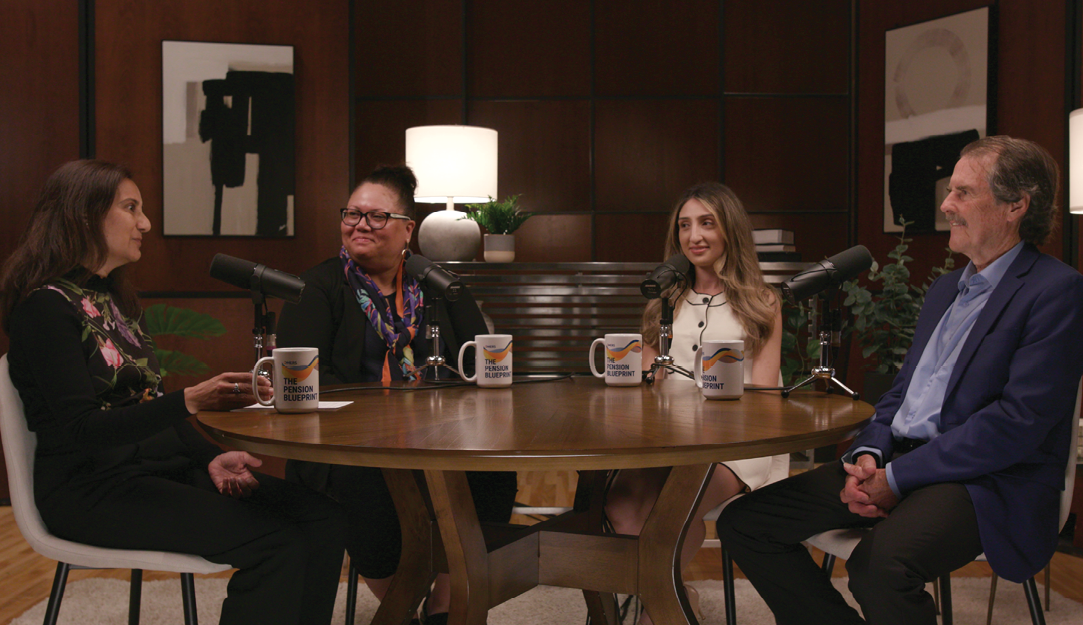 Four people sitting at a table with microphones