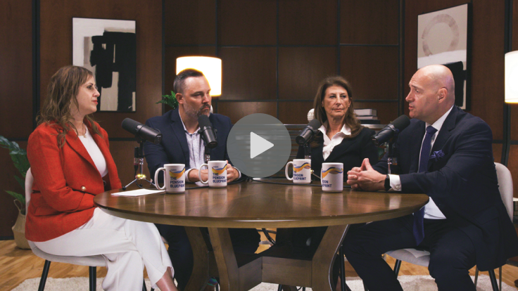 Four people sitting at a table with microphones